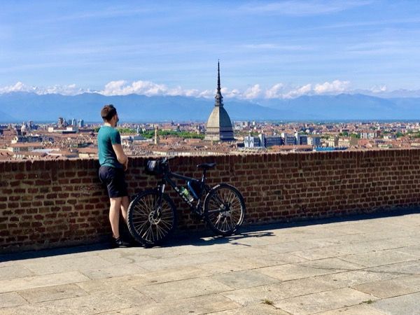 Rowerzysta patrzy na panoramę Turynu z Monte dei Cappuccini