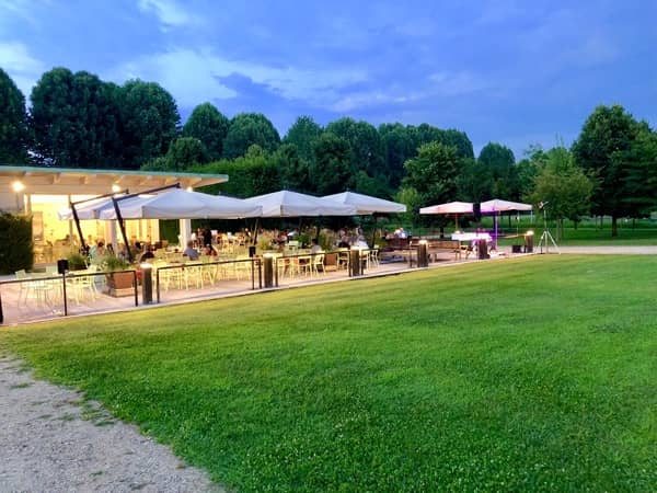 Parasole i stoliki barowe na otwartym powietrzu gdzie goście jedzą aperitivo we Włoszech