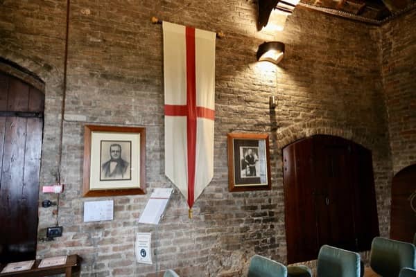Sala w której odbywa się międzynarodowa aukcja białych trufli, na ścianie flaga z herbem miasta Alby