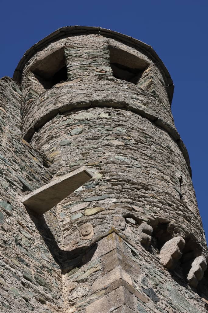Wieża zamku i tajemnicze kamienne twarze odstraszające złe duchy