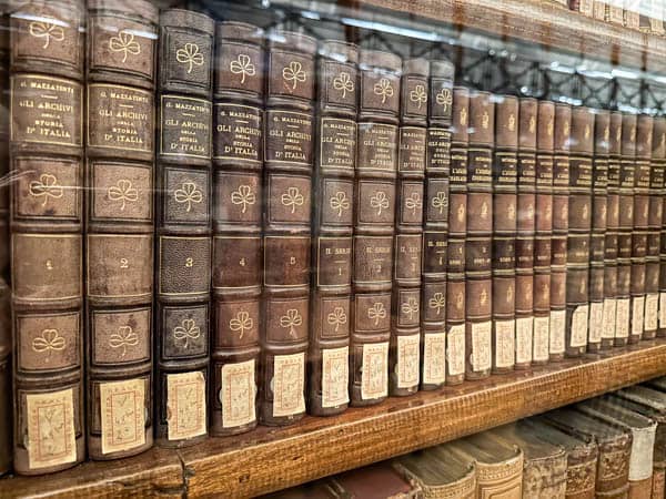 Stare książki na półkach w bibliotece królewskiej w Turynie