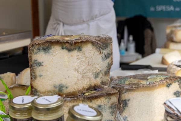 Dojrzewający ser z Turynu Castelmagno na straganie w czasie festynu gastronomicznego we Włoszech