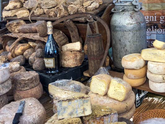 Sery z Piemontu i butelka wina na straganie kiermaszu gastronomicznego 